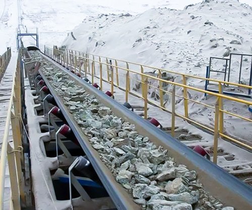 heavy stones being carried on Cold resistant conveyor belt. in hard cold snow Environment.