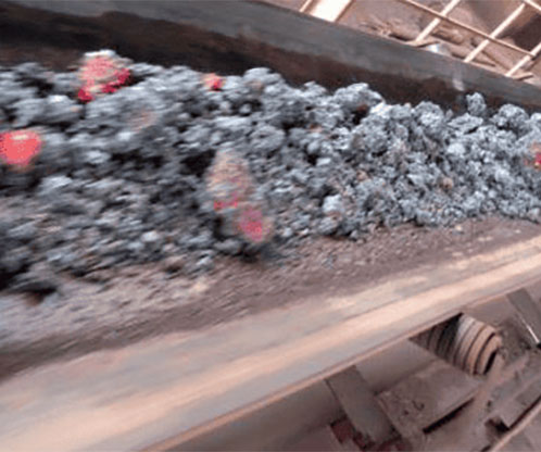 burning coal being conveyed on fire resistant conveyor belts